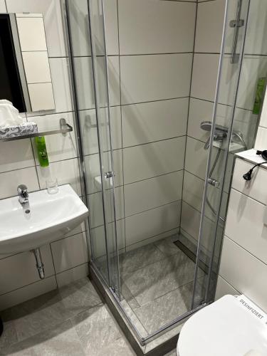 a bathroom with a shower and a toilet and a sink at Hotel JÄGERHAUS in Singen am Hohentwiel in Singen