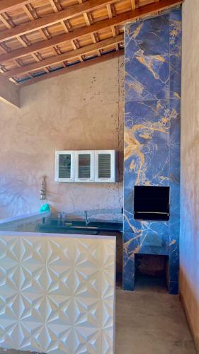 uma cozinha com um balcão e uma parede azul em area de lazer cinuca em Serrana