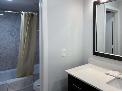 a bathroom with a sink and a toilet and a mirror at Motel 6 Greenville, NC ECU Medical Center in Greenville
