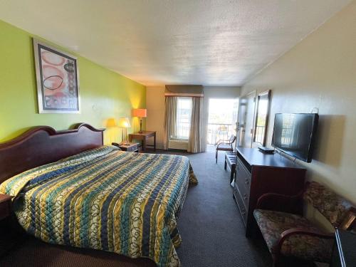 um quarto de hotel com uma cama e uma televisão de ecrã plano em Motel 6 Bracey, VA I 85 em Bracey