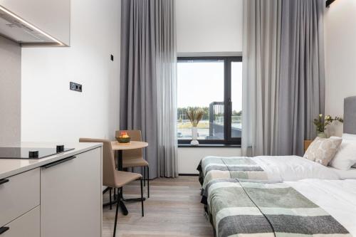 um quarto de hotel com uma cama e uma mesa em Väo Keskus Modern Guest Apartments em Talin