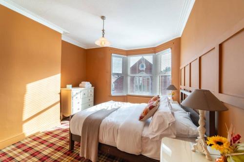 een slaapkamer met een groot bed en een raam bij Orange Rentals-Free Parking - 4-Bed home near Sefton Park in Liverpool