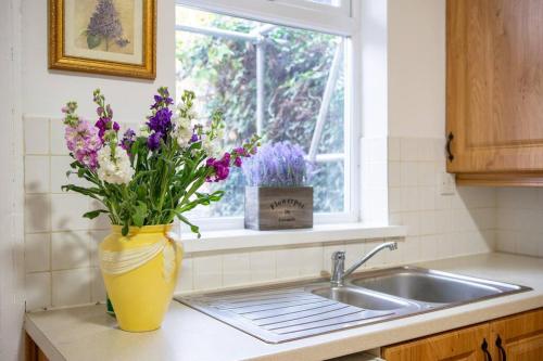 a vase of flowers sitting on a counter next to a sink at Orange Rentals-Free Parking - 4-Bed home near Sefton Park in Liverpool
