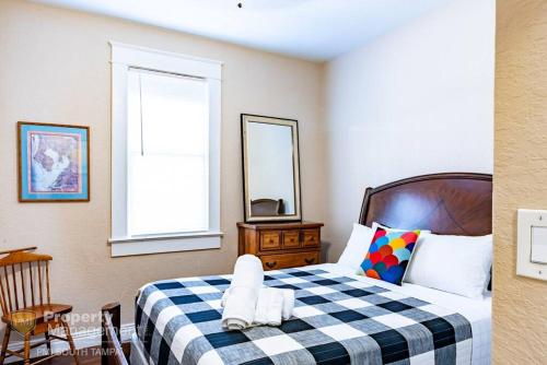 a bedroom with a bed with a checkered blanket at Breakfast Club - U of Tampa Flat in N Hyde Park in Tampa