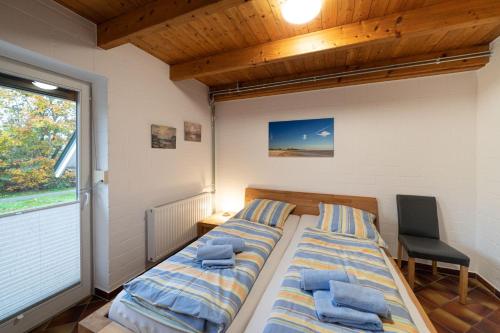 Un dormitorio con una cama con toallas azules. en Ferienhaus Austernfischer, en Otterndorf