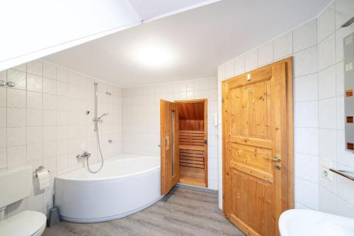 y baño con bañera, aseo y lavamanos. en Ferienhaus Austernfischer, en Otterndorf