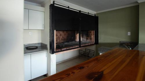 a kitchen with a wooden table and a fireplace at Dpto sobre Bv Galvez con Piscina in Santa Fe