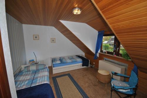 um quarto no sótão com 2 camas e uma janela em Ferienhaus Medemsonne em Otterndorf
