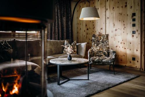 a living room with a couch and a table and a chair at Rieser Achensee Resort in Pertisau