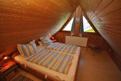 a bedroom with a bed in a log cabin at Ferienhaus Sturmtaucher in Otterndorf
