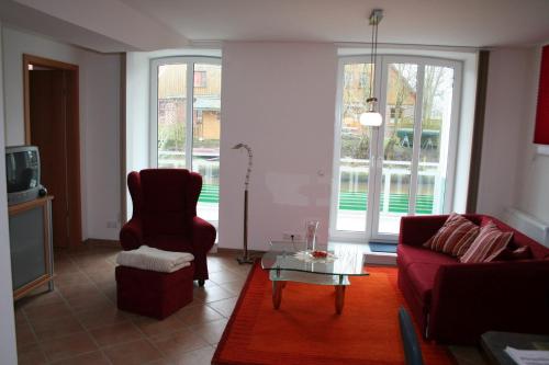een woonkamer met een rode bank en een tafel bij Ferienwohnung Korte in Otterndorf