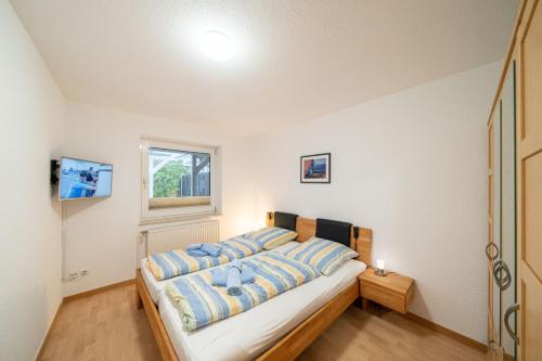ein Schlafzimmer mit einem großen Bett mit blauen Kissen in der Unterkunft Ferienhaus Seestern II in Otterndorf