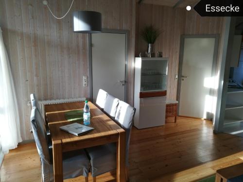 ein Esszimmer mit einem Holztisch und Stühlen in der Unterkunft Ferienhaus Südsee 26 in Otterndorf