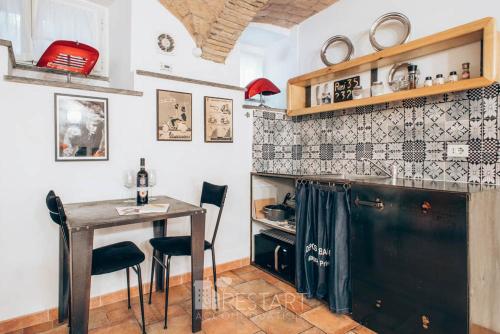 a kitchen with a table and chairs in a room at Restart Accommodations Balestra in Rome