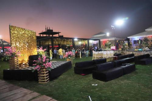 a group of black couches on the grass at night at Ananda Resort in Pushkar