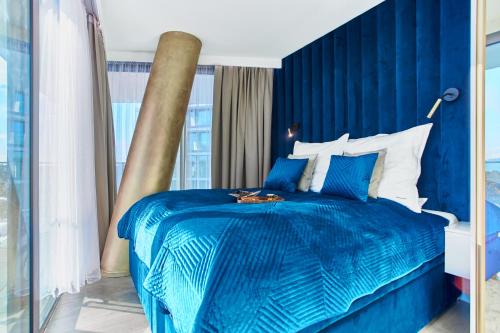 a blue bedroom with a large bed with blue sheets at Your Holidays Waves Złote Filary D653 in Międzyzdroje