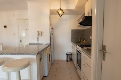 a kitchen with white cabinets and a counter top at Dpto sobre Bv Galvez con Piscina in Santa Fe
