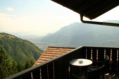 a balcony with a table and a view of a mountain at Panoramapension Etschblick in Meltina