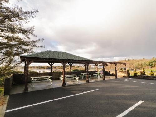 a parking lot with a pavilion with benches at The Wheelhouse Pod No 1 in Burtonport