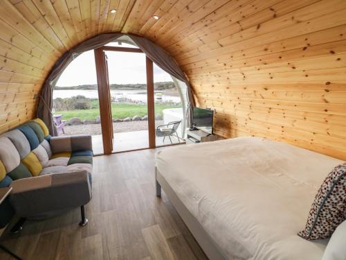 - une chambre avec un lit, un canapé et une fenêtre dans l'établissement The Wheelhouse Pod No 3, à Letterkenny