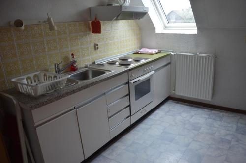 a kitchen with white cabinets and a sink and a window at Harten in Büchen