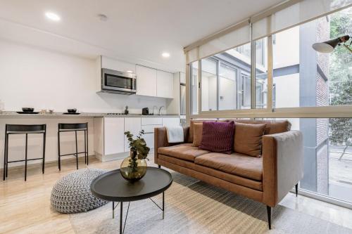 a living room with a couch and a table at Benjamin Franklin 175, in Condesa by Blueground in Mexico City