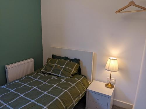 a bedroom with a bed and a lamp on a night stand at Dolce Central Lord St. Flat 2 in Southport