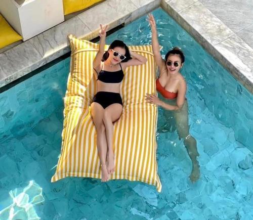 two women in bathing suits sitting on rafts in a swimming pool at Thandara kohlarn in Ko Larn