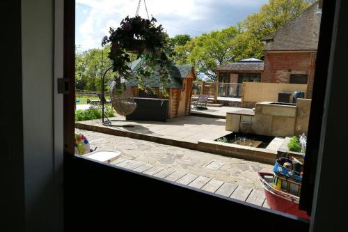 a view of a garden from a window of a house at The Stables - 2 bed with large garden and hot tub. in Sway