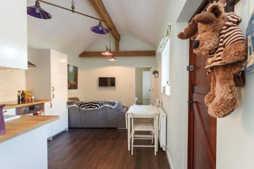 The Stables - 2 bed with large garden and hot tub. في Sway: مطبخ وغرفة معيشة مع طاولة وحشرات على الحائط