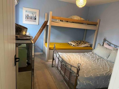 a bedroom with two bunk beds in a room at The Stables - 2 bed with large garden and hot tub. in Sway