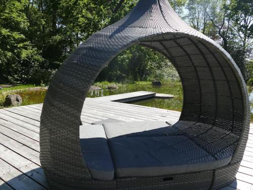 a wicker chair sitting on a wooden deck at The Stables - 2 bed with large garden and hot tub. in Sway