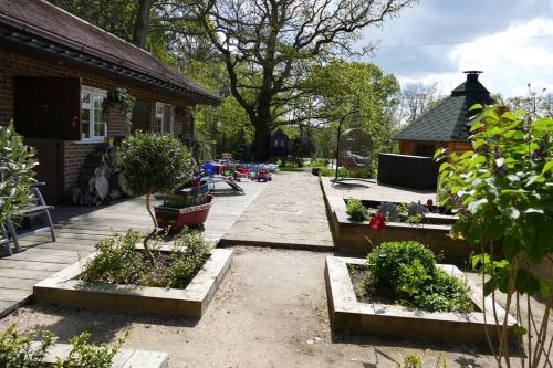 a garden with some plants and a house at The Stables - 2 bed with large garden and hot tub. in Sway