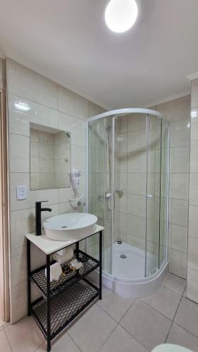 a bathroom with a shower and a sink and a tub at Robinson Alojamientos - Edificio Erico Orlando in Ushuaia