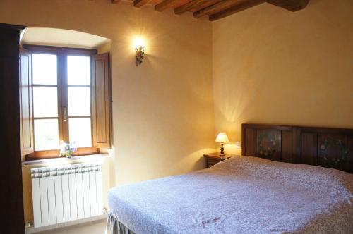 a bedroom with a large bed and a window at Fattoria Poggerino in Radda in Chianti