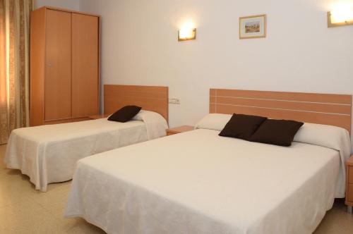 two beds in a hotel room with two beds at Pension Canadiense in Barcelona
