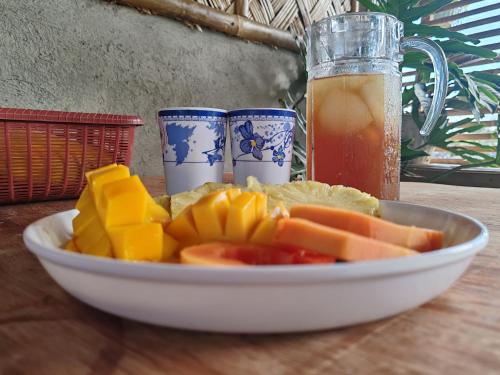 a bowl of fruit and a glass of juice on a table at Dream house 