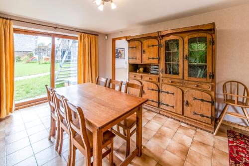 a dining room with a wooden table and chairs at La Ruche de Raphaëlle in Clavier