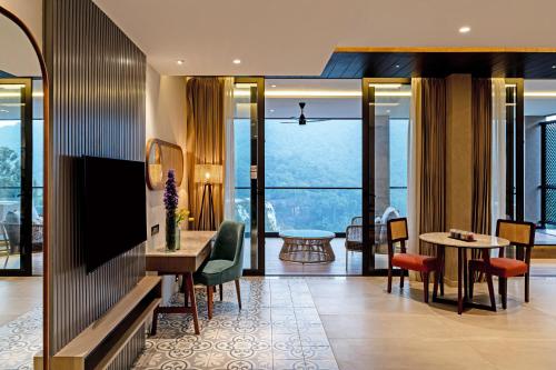 a hotel room with a view of a living room at Flora Misty Falls Athirappilly in Athirappilly