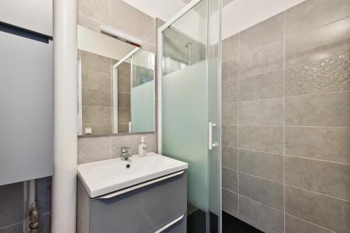 a bathroom with a sink and a mirror at Appartement F3 15 mins à Paris in Aubervilliers