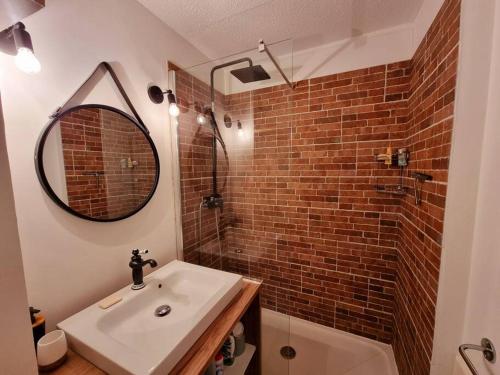 La salle de bains est pourvue d'un lavabo et d'un mur en briques. dans l'établissement Studio Cosy Atypique - Toulouse, à Toulouse
