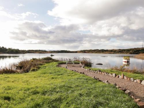 a path across a lake with a boat in the water at The Wheelhouse Pod No 6 in Letterkenny
