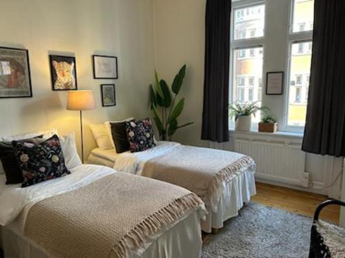 1 dormitorio con 2 camas y ventana en Stockholm Loft Haven 3 Beds in a 1- Bedroom Gem - 917, en Estocolmo