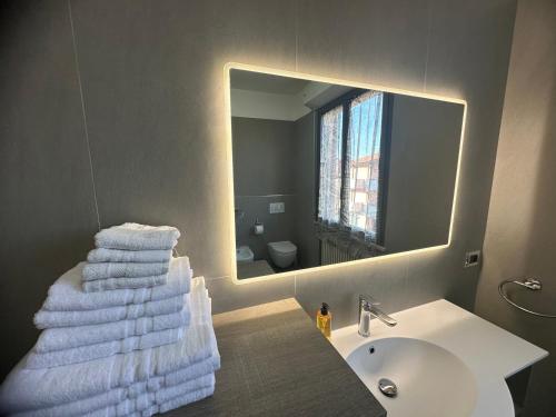 a bathroom with a sink and a mirror and towels at Beach House Fronte Mare Viserba in Rimini