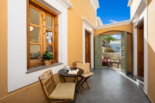 a balcony with a table and chairs and a window at Over The Sea Apartments in Symi