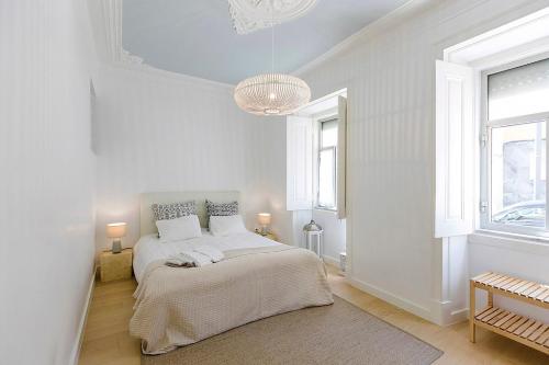a white bedroom with a bed and two windows at BELEM PLACE - free parking area in Lisbon