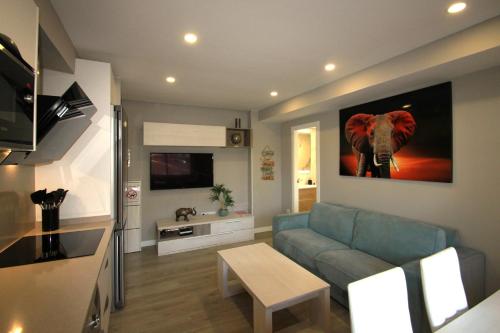 una sala de estar con sofá y una pintura de elefante en la pared en Apartamento CasaTuris en 1ª Línea Muchavista Edificio Voramar C106, en El Campello