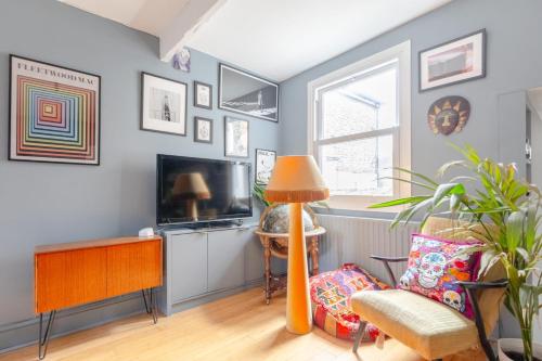 a living room with blue walls and a television at Stylish 2BD Home wPrivate Gym & Garden Newlands! in London