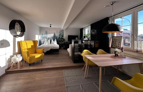 ein Wohnzimmer mit gelben Stühlen und einem Tisch in der Unterkunft Urban Studio in Buttelstedt