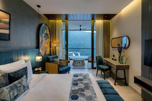 um quarto de hotel com uma cama e uma secretária em Flora Misty Falls Athirappilly em Athirappilly